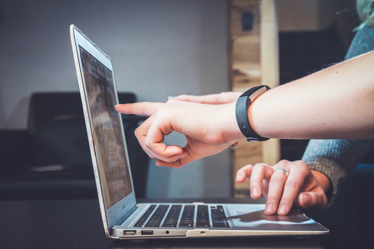 Hands reviewing data on a laptop screen